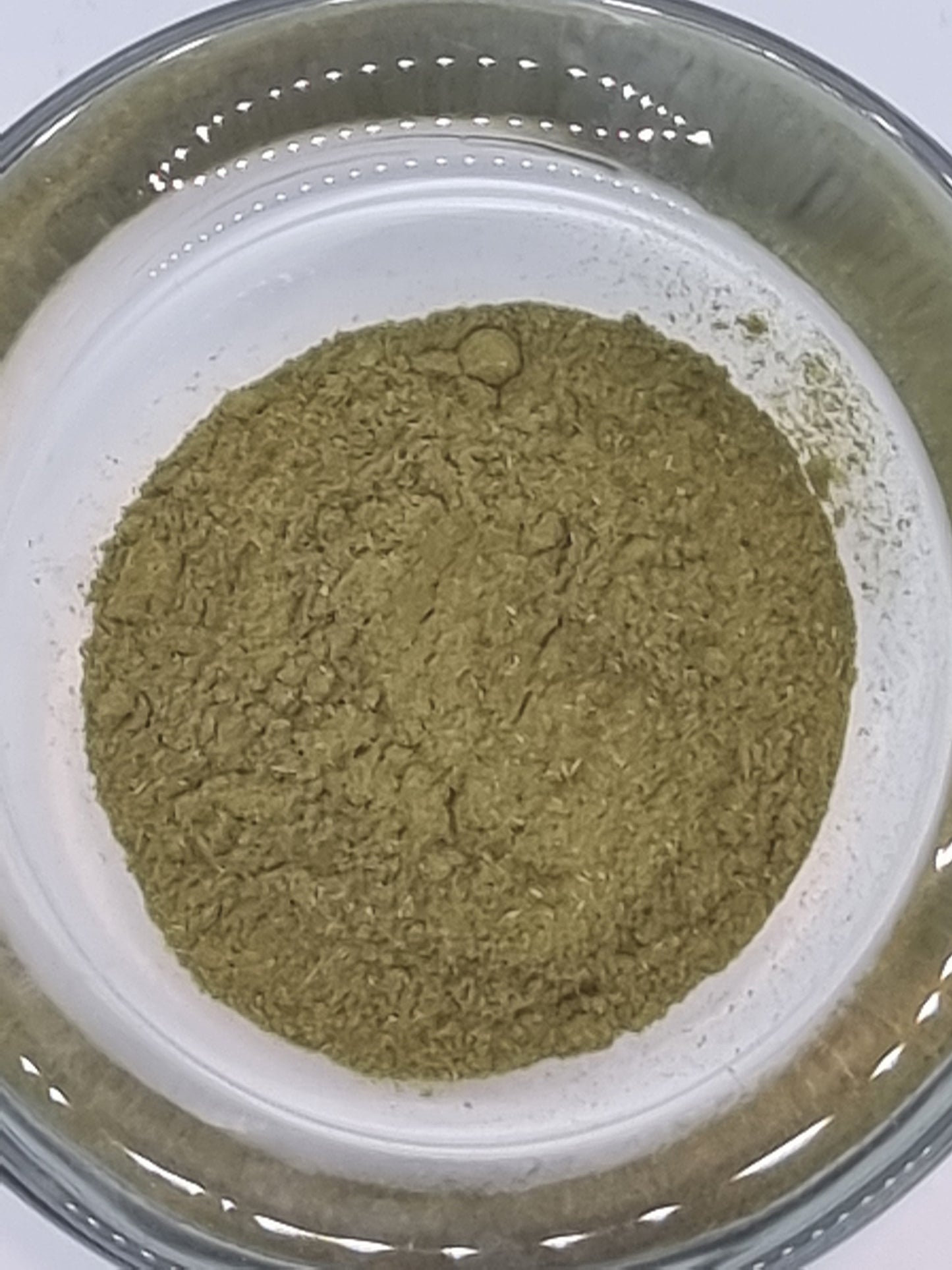 Finely ground green bay leaves in a glass dish