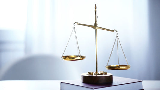 The scales of justice resting on a book, a decorative image thought to represent the legal requirements behind CPSRs