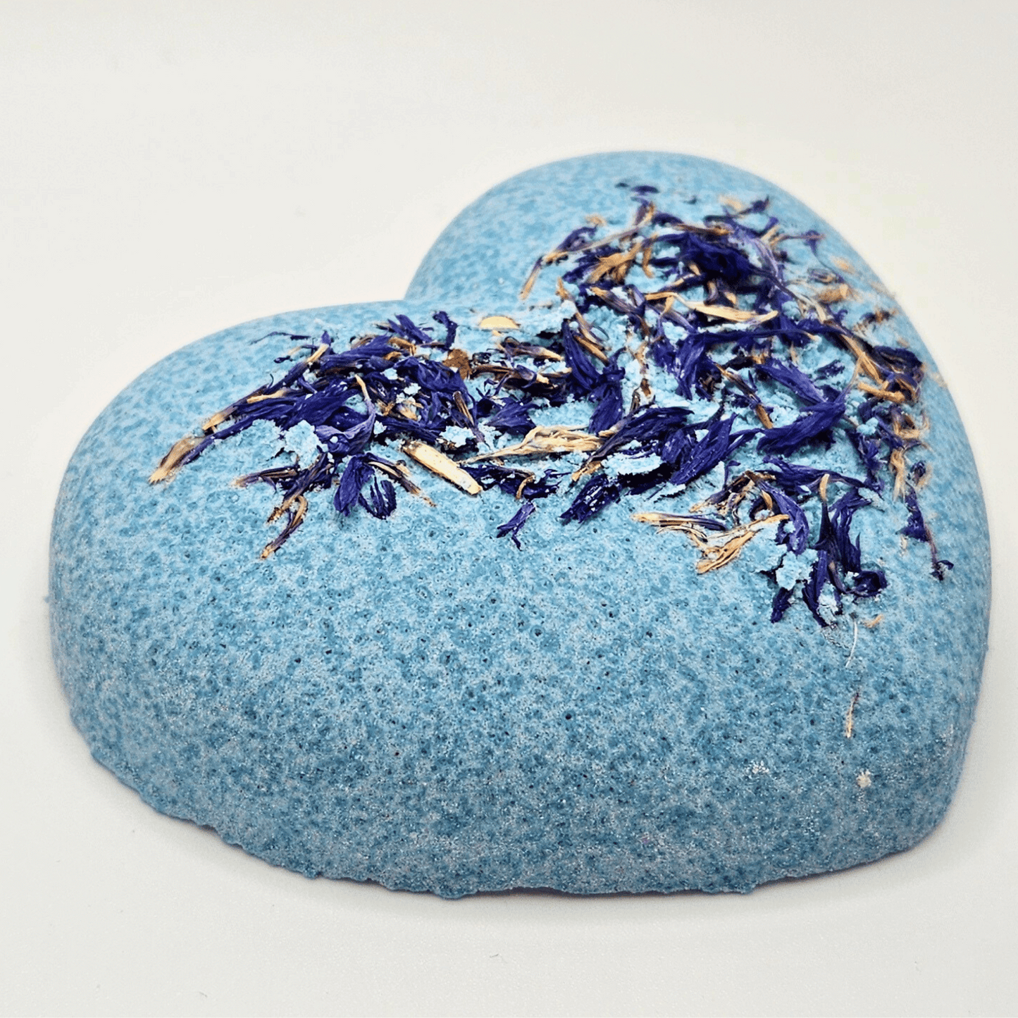 Heart shaped bath bomb with blue cornflower petals and coloured with bright blue natural clay