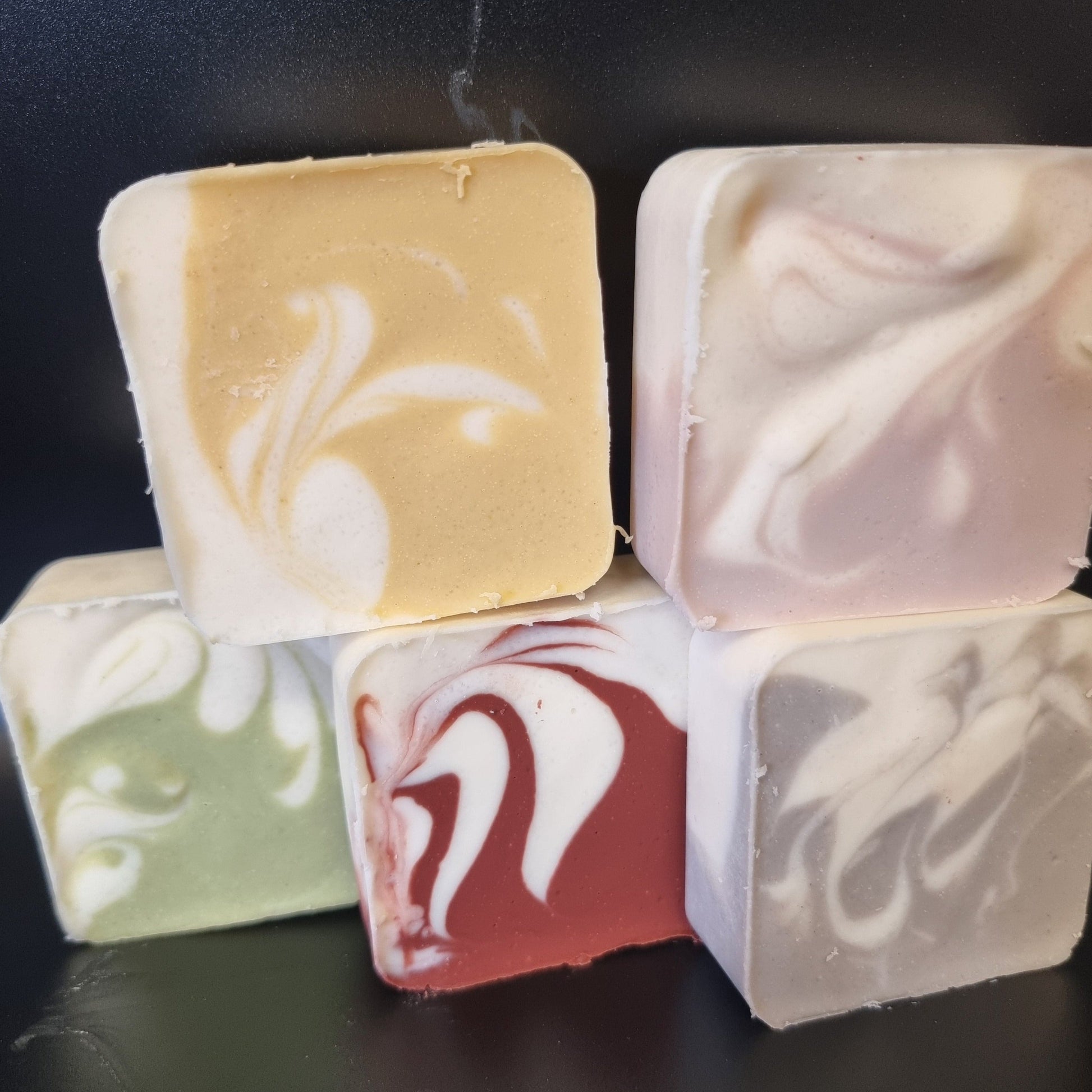 5 natural CP soaps containing swirls of colour made using yellow, green, red, purple and blue clay