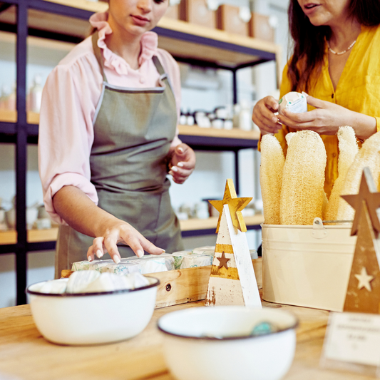 Image of a bath and body product shop with two women looking at soaps